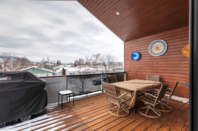 snow covered deck with outdoor dining space and area for grilling