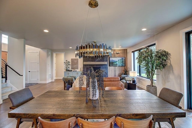 dining room with a fireplace, recessed lighting, stairway, wood finished floors, and baseboards