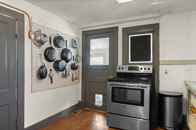 kitchen featuring dark wood-style floors, stainless steel range with electric stovetop, and baseboards