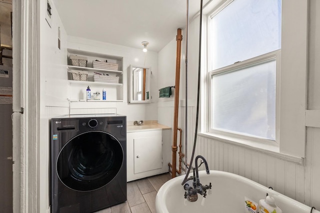 clothes washing area featuring washer / clothes dryer and a sink