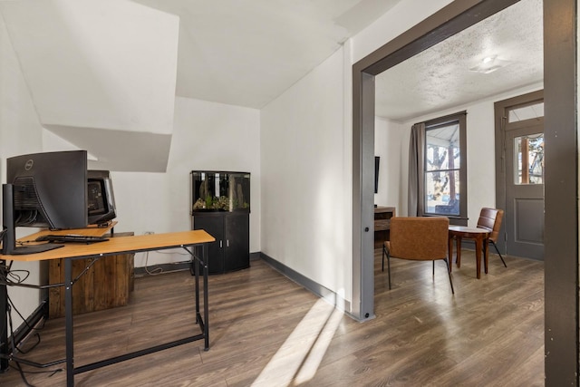 office area featuring a textured ceiling, baseboards, and wood finished floors