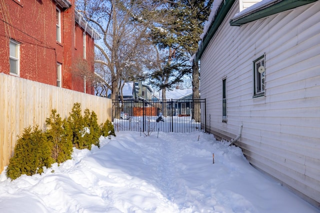 yard layered in snow featuring fence