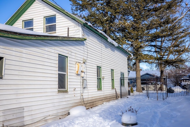 view of snow covered exterior featuring fence