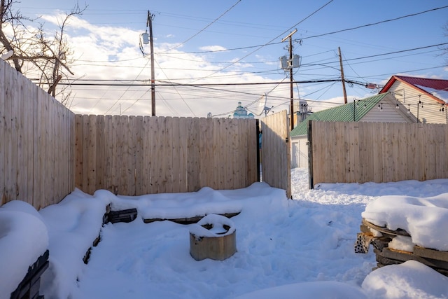 yard layered in snow featuring fence