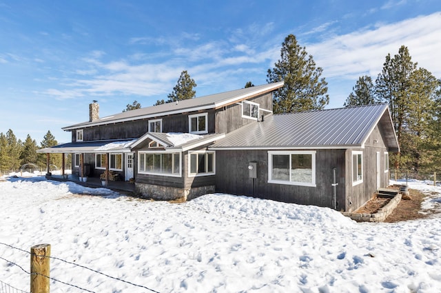 view of front of property with a chimney and metal roof