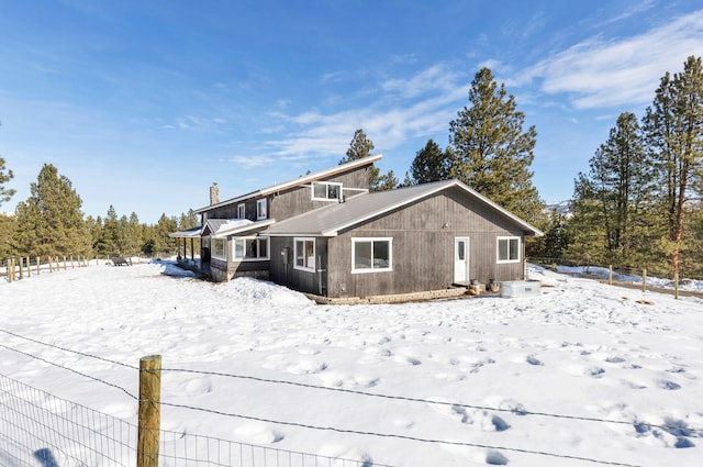 view of snow covered back of property