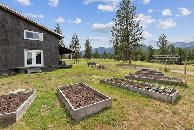 view of yard with a garden, a rural view, a mountain view, and french doors