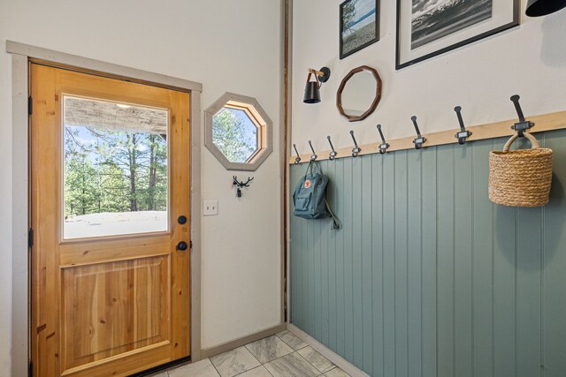 entryway with marble finish floor and baseboards