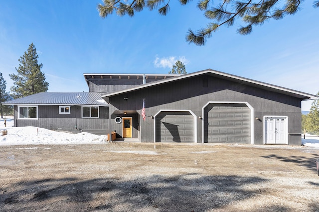 view of front facade featuring metal roof, driveway, and an attached garage