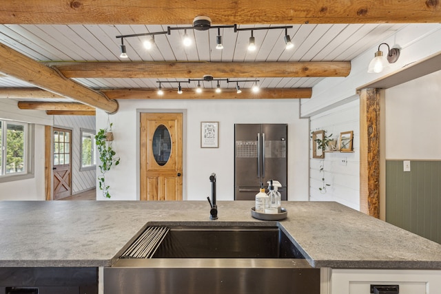 kitchen with freestanding refrigerator, beam ceiling, wooden ceiling, and a sink