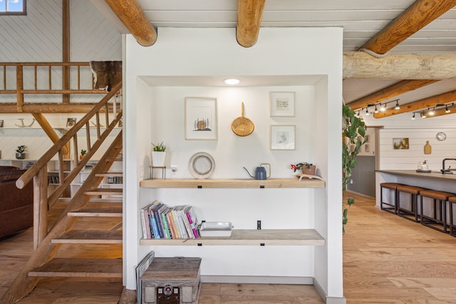 interior space with wood finished floors, beam ceiling, and wooden walls