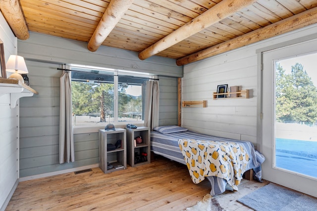 bedroom with wooden ceiling, light wood finished floors, multiple windows, and beam ceiling