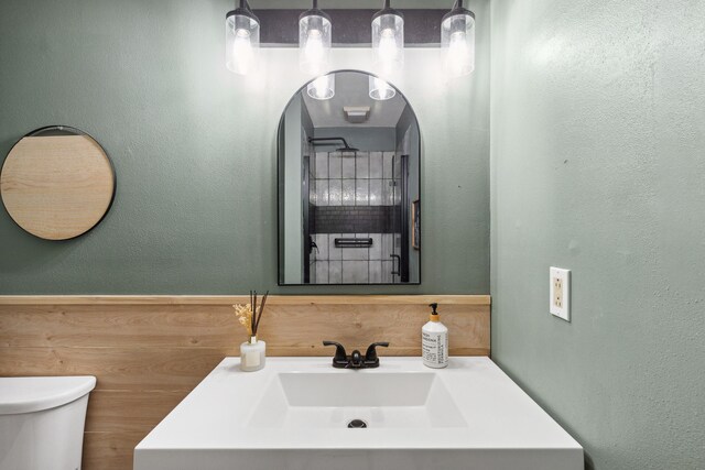 bathroom featuring a textured wall, vanity, and toilet