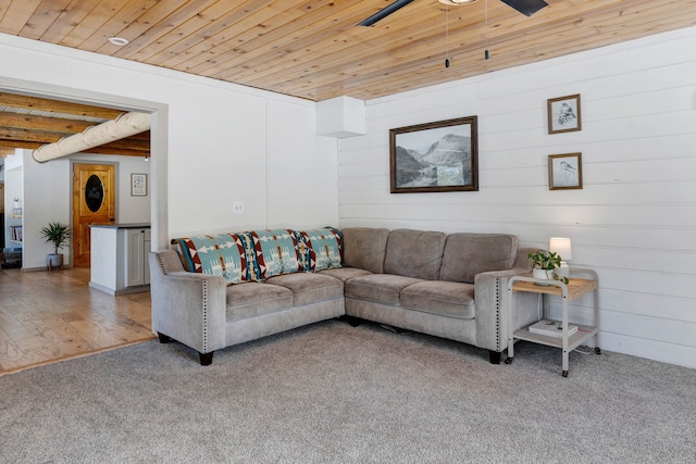 carpeted living area featuring ceiling fan, wooden ceiling, and wood finished floors