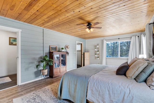 bedroom with baseboards, a ceiling fan, wood ceiling, and light wood-style floors