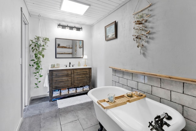 bathroom featuring tile patterned flooring, a soaking tub, and vanity