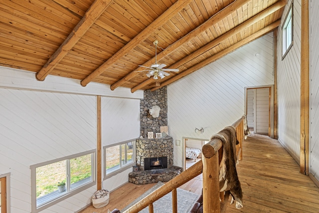 living area featuring wooden walls, a fireplace, wood ceiling, hardwood / wood-style floors, and beamed ceiling