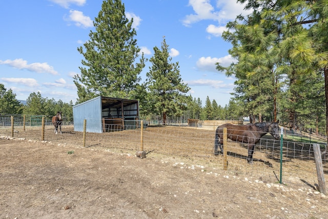 view of yard with an outbuilding, an exterior structure, and a rural view