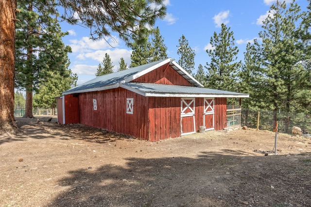 view of outdoor structure featuring an outbuilding and fence