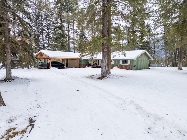 yard layered in snow with a garage and a carport