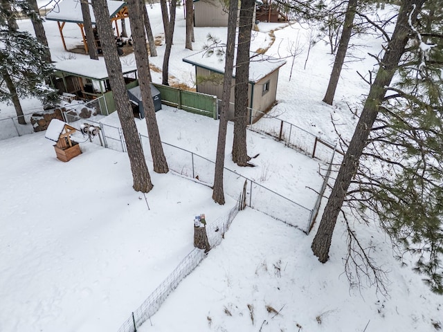 yard layered in snow featuring a garage and fence