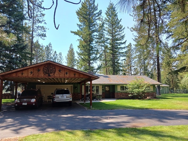 ranch-style house featuring brick siding, aphalt driveway, a carport, and a front yard