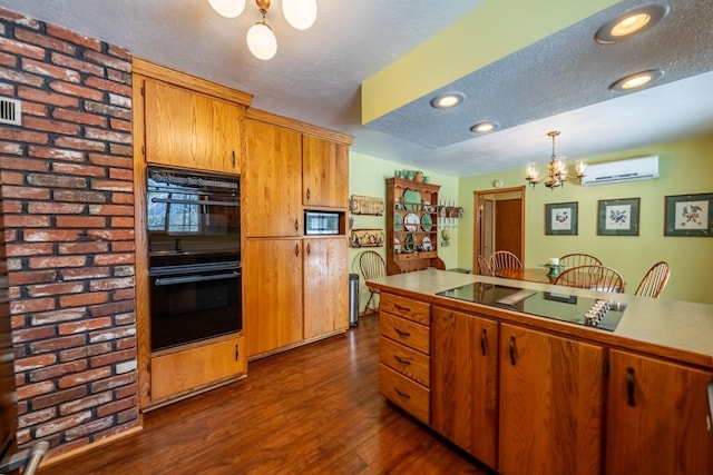 kitchen featuring a chandelier, hanging light fixtures, a wall mounted AC, black appliances, and brown cabinetry