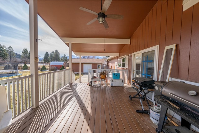 deck with ceiling fan, a trampoline, and a grill