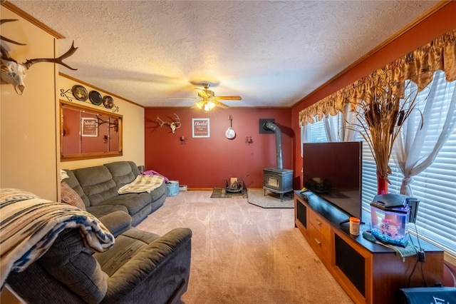 living room with crown molding, a wood stove, light carpet, ceiling fan, and a textured ceiling