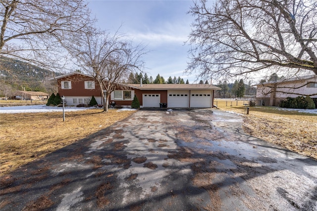 view of front of property with a garage, driveway, and fence