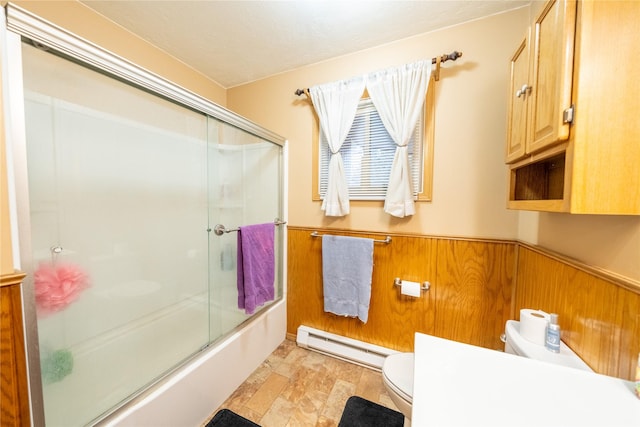 bathroom with a baseboard radiator, toilet, enclosed tub / shower combo, wainscoting, and wood walls