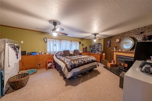 647 Northwood Ave, Libby, MT 59923 - bedroom with a wood stove, carpet flooring, a textured ceiling, a ceiling fan, and brick wall