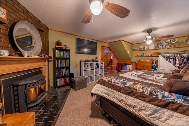 bedroom with dark colored carpet, a wood stove, crown molding, and a textured ceiling