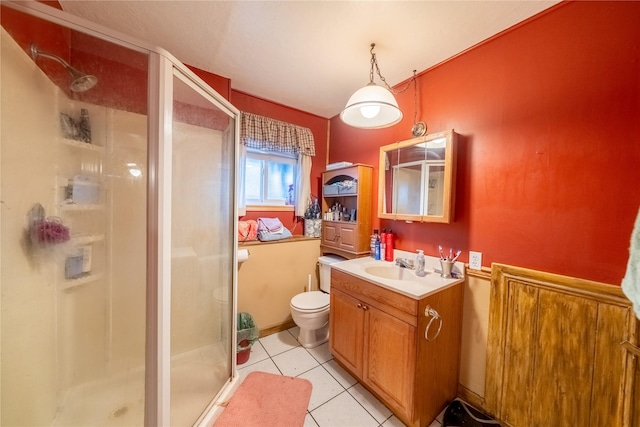 bathroom featuring toilet, a stall shower, tile patterned floors, and vanity