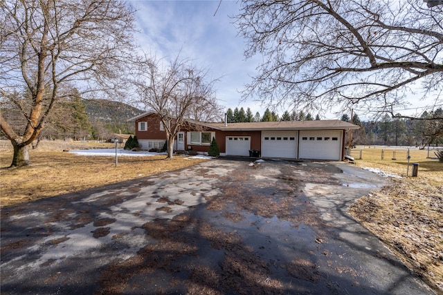 single story home with aphalt driveway, an attached garage, and a mountain view