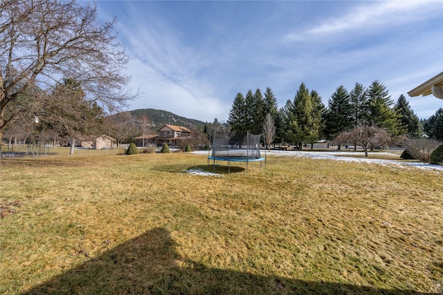 view of yard with a trampoline and a mountain view