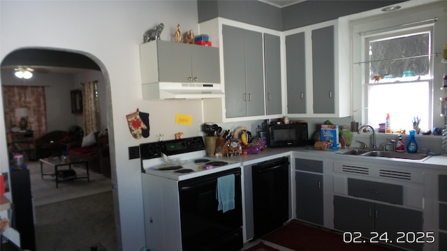 kitchen with arched walkways, under cabinet range hood, a sink, light countertops, and black appliances