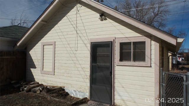 view of property exterior featuring roof with shingles and fence