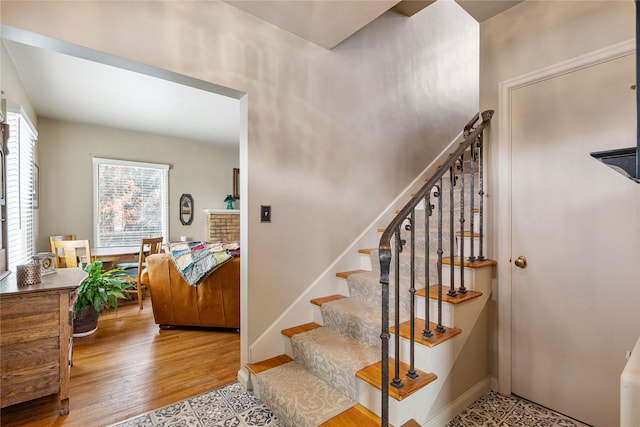 stairway featuring baseboards and wood finished floors