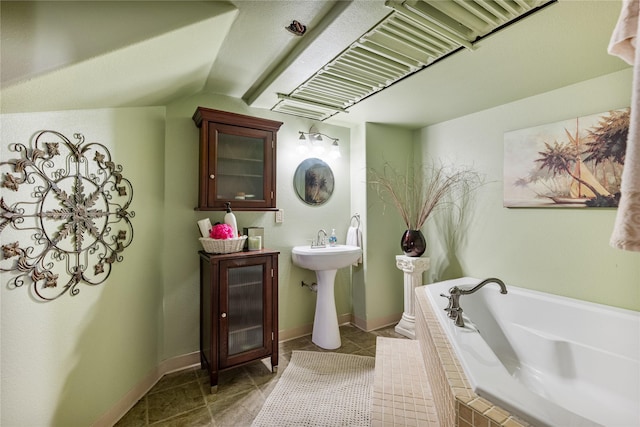 bathroom with lofted ceiling, a sink, baseboards, and a bath