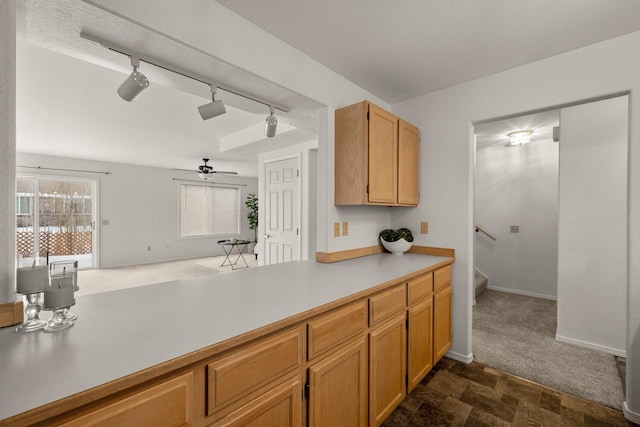 312 Ponderosa St, Kalispell, MT 59901 - kitchen featuring rail lighting, light countertops, open floor plan, dark colored carpet, and ceiling fan