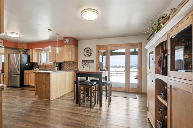 kitchen with pendant lighting, light countertops, a water view, and light brown cabinets