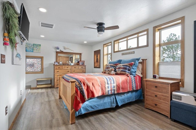 bedroom featuring baseboards, visible vents, wood finished floors, and recessed lighting