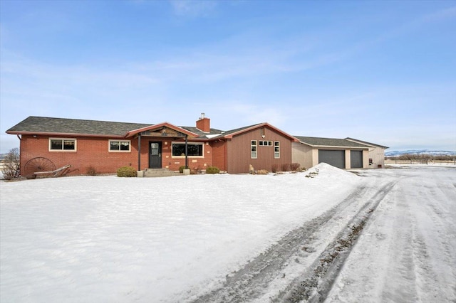 single story home featuring brick siding and a chimney