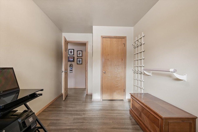 corridor featuring baseboards and dark wood-style flooring