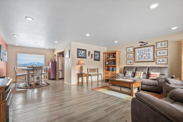 living room with baseboards, wood finished floors, and recessed lighting