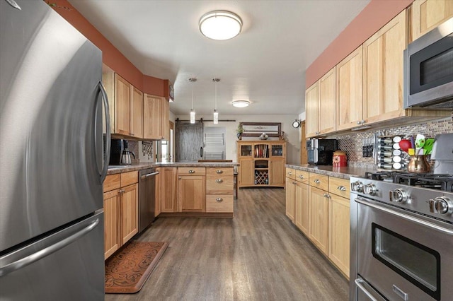 kitchen with tasteful backsplash, dark wood-style floors, hanging light fixtures, a peninsula, and stainless steel appliances