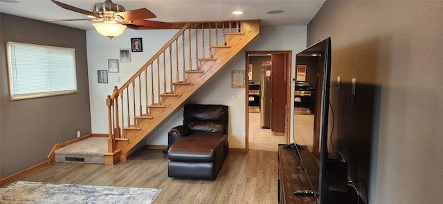 staircase with ceiling fan, visible vents, baseboards, and wood finished floors