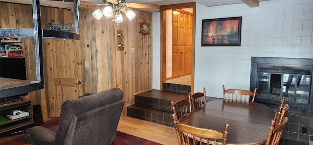 dining room with ceiling fan, wood finished floors, and a glass covered fireplace