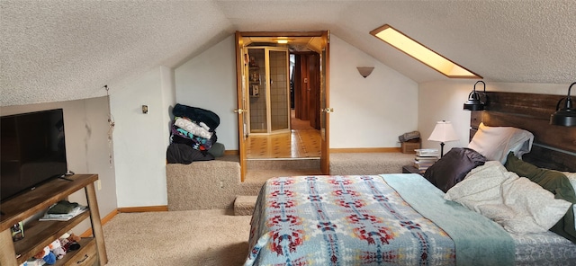 bedroom with vaulted ceiling with skylight, light colored carpet, a textured ceiling, and baseboards